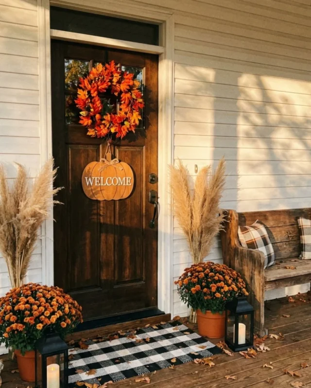 Beautiful fall front porch decor featuring pumpkins, mums, and cozy elements