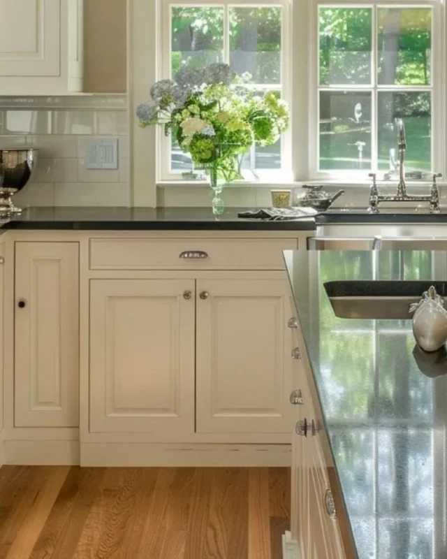 Kitchen design showcasing black counters and cream cabinets in a Martha Stewart inspired style.